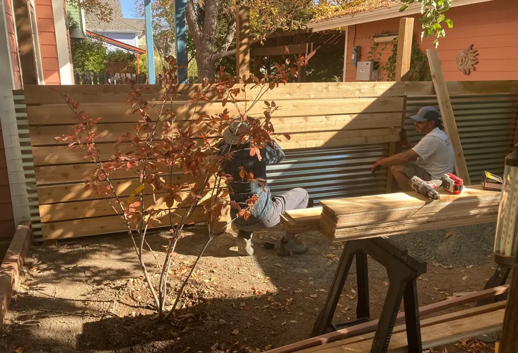 Blue Spruce Horticulture team members installing a fence in a backyard.