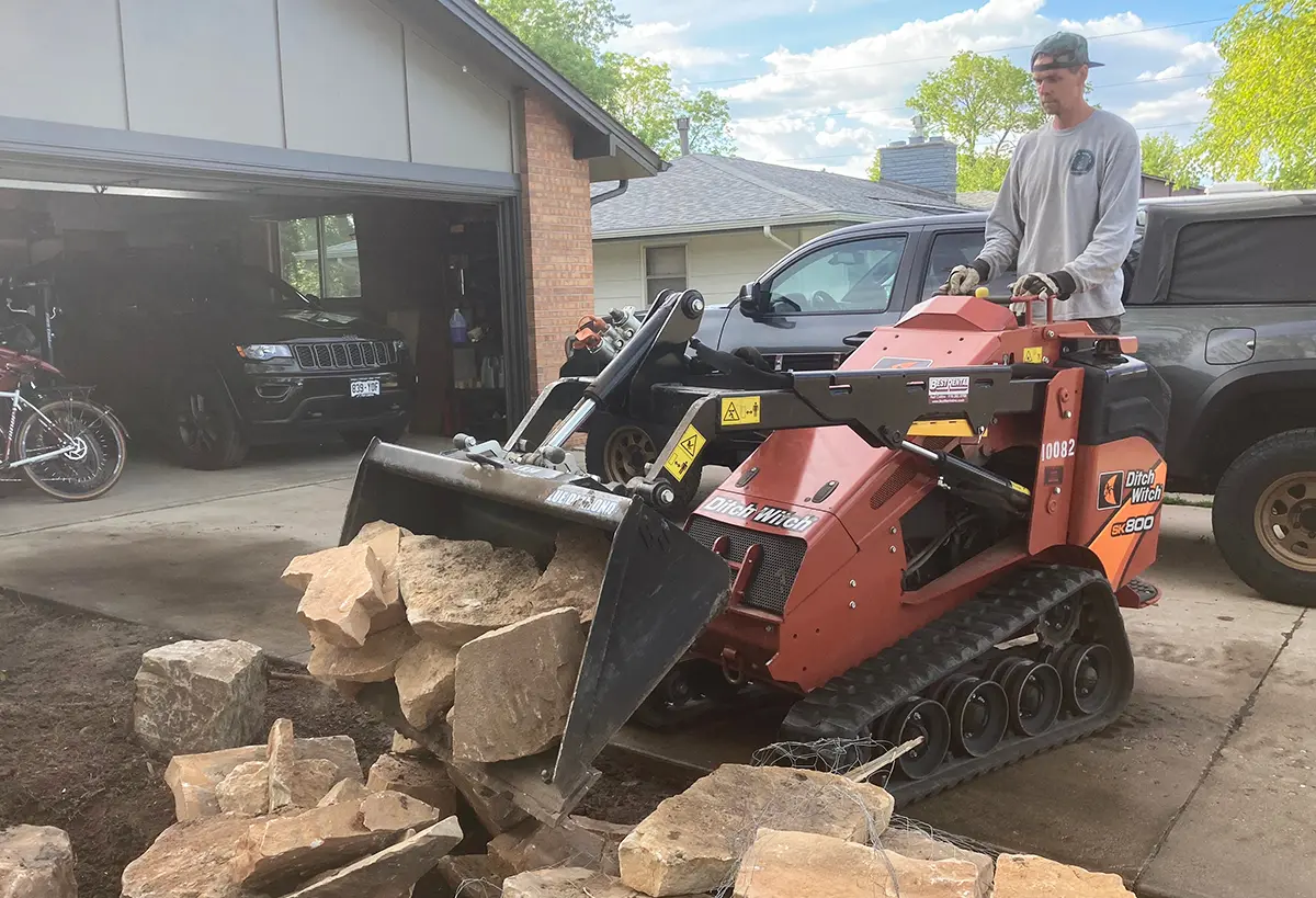 Stuart Shoemaker operating a heavy machine during a install for Blue Spruce Horticulture.